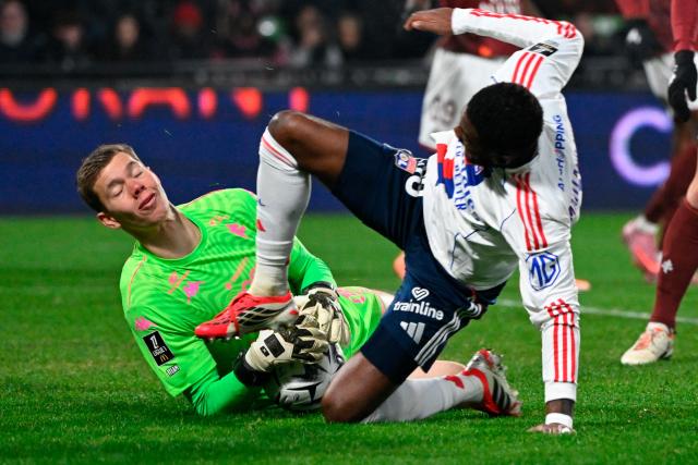 Lyon’s English midfielder #98 Ainsley Maitland-Niles (R) fights for the ball with Metz’s Danish goalkeeper #01 Jonathan Fischer during the French L1 football match between Metz and Olympique Lyonnais (OL) at the Stade Saint-Symphorien in Longeville-les-Metz, eastern France, on January 25, 2026. (Photo by Jean-Christophe VERHAEGEN / AFP)