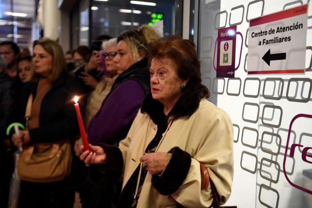 A woman holds a candle as she attends a vigil in honour of the victims of the January 18 high-speed train accident that killed 45 people in Adamuz, on January 25, 2026, at the railway station of Huelva. One week after the train disaster involving two trains in southern Spain, which left 45 dead, remembrance ceremonies took place today in Huelva, where most of the victims came from, and in the town of Adamuz, where the collision occurred. (Photo by CRISTINA QUICLER / AFP)