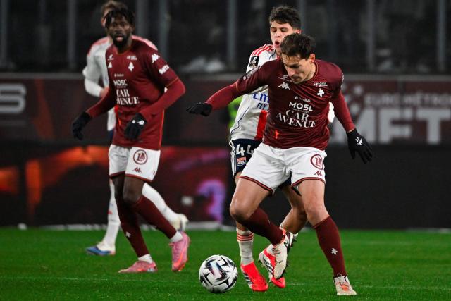 Lyon’s French midfielder #44 Khalis Merah (L) fights for the ball with Metz’s French midfielder #21 Benjamin Stambouli during the French L1 football match between Metz and Olympique Lyonnais (OL) at the Stade Saint-Symphorien in Longeville-les-Metz, eastern France, on January 25, 2026. (Photo by Jean-Christophe VERHAEGEN / AFP)