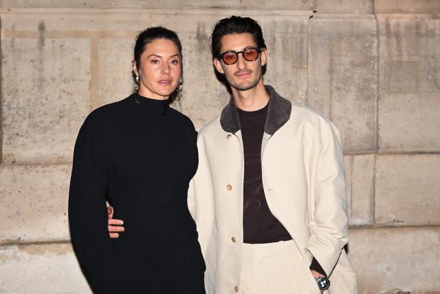 French actor Pierre Niney (R) and his wife Australian actress Natasha Andrews pose for a photocall upon arrival to attend the Jacquemus Menswear ready-to-wear Fall-Winter 2026/2027 collection as part of the Men Paris Fashion Week in Paris on January 25, 2026. (Photo by Blanca CRUZ / AFP)
