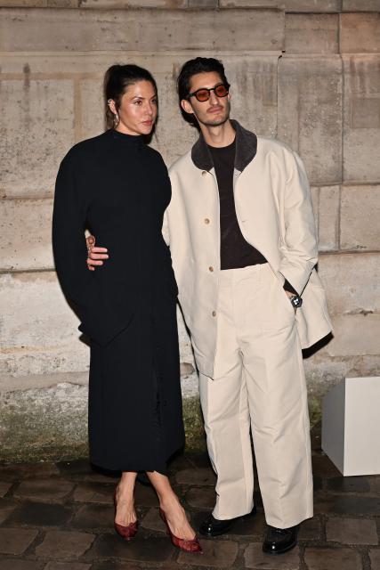 French actor Pierre Niney (R) and his wife Australian actress Natasha Andrews pose for a photocall upon arrival to attend the Jacquemus Menswear ready-to-wear Fall-Winter 2026/2027 collection as part of the Men Paris Fashion Week in Paris on January 25, 2026. (Photo by Blanca CRUZ / AFP)