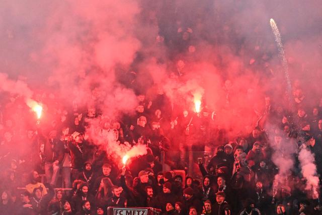 Metz’s supporters light smoke flares and fireworks during the French L1 football match between Metz and Olympique Lyonnais (OL) at the Stade Saint-Symphorien in Longeville-les-Metz, eastern France, on January 25, 2026. (Photo by Jean-Christophe VERHAEGEN / AFP)