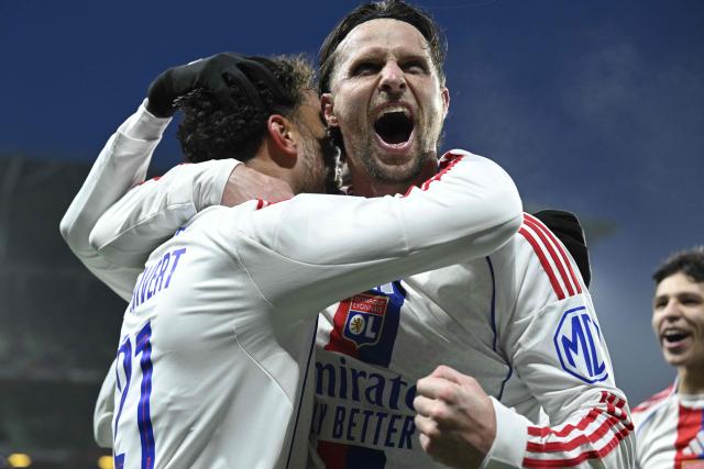 Lyon's Dutch defender #21 Ruben Kluivert (L) celebrates with Lyon's Dutch defender #33 Hans Hateboer (C) after scoring a goal during the French L1 football match between Metz and Olympique Lyonnais (OL) at the Stade Saint-Symphorien in Longeville-les-Metz, eastern France, on January 25, 2026. (Photo by Jean-Christophe VERHAEGEN / AFP)