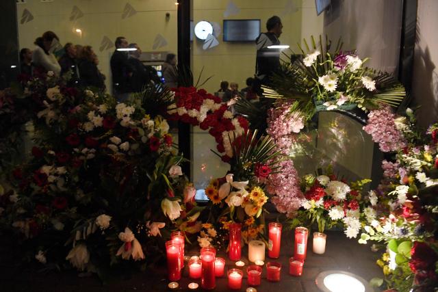 Floral wreaths and candles are seen at the entrance of the Huelva railway station where people attend a vigil in honour of the victims of the January 18 high-speed train accident that killed 45 people in Adamuz, on January 25, 2026, in Huelva. One week after the train disaster involving two trains in southern Spain, which left 45 dead, remembrance ceremonies took place today in Huelva, where most of the victims came from, and in the town of Adamuz, where the collision occurred. (Photo by CRISTINA QUICLER / AFP)
