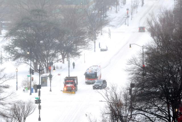 Vehicles make their way through downtown Washington, DC, on January 25, 2026. A massive winter storm on January 24 dumped snow and freezing rain from New Mexico to North Carolina as it swept across the United States towards the northeast, threatening tens of millions of Americans with blackouts, transportation chaos and bone-chilling cold. After battering the country's southwest and central areas, the storm system began to hit the heavily populated mid-Atlantic and northeastern states as a frigid air mass settled in across the nation. (Photo by Alex WROBLEWSKI / AFP)