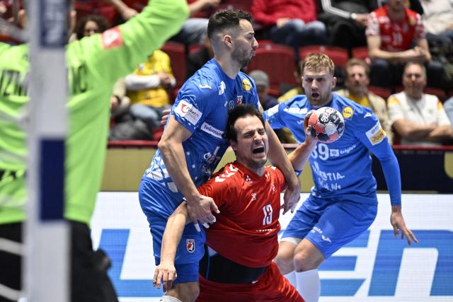 Croatia's left back #11 Zvonimir Srna (L) and Switzerland's right back #13 Michael Kusio (C) vie for the ball during the men's EHF Euro 2026 main round handball match Switzerland v Croatia in Malmo, Sweden, on January 25, 2026. (Photo by Johan Nilsson/TT / TT NEWS AGENCY / AFP) / Sweden OUT