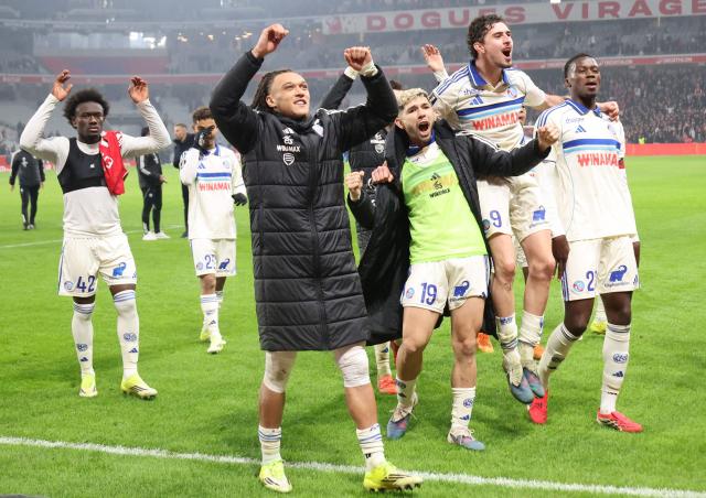 Strasbourg's players celebrate their victory at the end of the French L1 football match between Lille LOSC and RC Strasbourg Alsace at the Stade Pierre-Mauroy in Villeneuve-d'Ascq, northern France, on January 25, 2026. (Photo by Francois LO PRESTI / AFP)