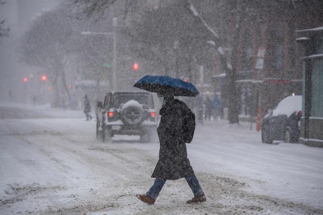A person crosses the street in Copley Square during a snowstorm in Boston, Massachusetts, on January 25, 2026. A massive winter storm headed towards the northeast United States after sweeping across much of the country, threatening tens of millions of Americans with blackouts, transportation chaos and bone-chilling cold. After battering the country's southwest and central areas, the storm system began to hit the heavily populated mid-Atlantic and northeastern states with snow and freezing rain as a frigid air mass settled in across the nation. (Photo by Joseph Prezioso / AFP)