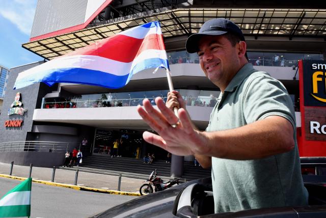 Costa Rica's presidential candidate of the Liberation party, Alvaro Ramos, waves as he holds a national flag during his closing campaign rally in San Jose on January 25, 2026. Right-wing politician Laura Fernandez appears set to win Costa Rica's presidential election in the first round, according to two opinion polls published on January 21. (Photo by EZEQUIEL BECERRA / AFP)