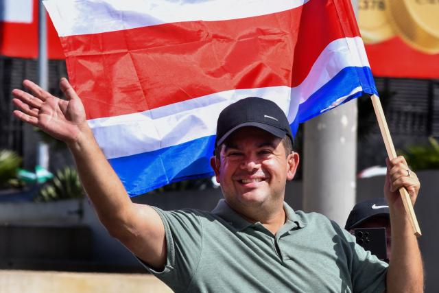Costa Rica's presidential candidate of the Liberation party, Alvaro Ramos, waves as he holds a national flag during his closing campaign rally in San Jose on January 25, 2026. Right-wing politician Laura Fernandez appears set to win Costa Rica's presidential election in the first round, according to two opinion polls published on January 21. (Photo by EZEQUIEL BECERRA / AFP)