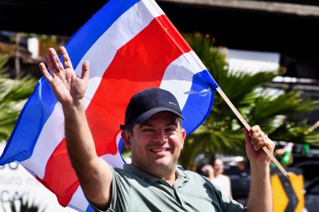 Costa Rica's presidential candidate of the Liberation party, Alvaro Ramos, waves as he holds a national flag during his closing campaign rally in San Jose on January 25, 2026. Right-wing politician Laura Fernandez appears set to win Costa Rica's presidential election in the first round, according to two opinion polls published on January 21. (Photo by EZEQUIEL BECERRA / AFP)