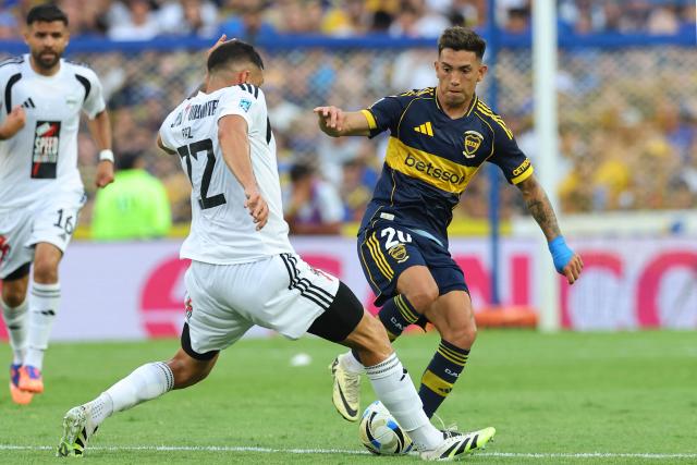 Deportivo Riestra's defender #22 Cristian Paz and Boca Juniors' forward #20 Alan Velasco fight for the ball during the Argentine Professional Football League 2026 Apertura Tournament match between Boca Juniors and Deportivo Riestra at La Bombonera Stadium in Buenos Aires on January 25, 2026. (Photo by ALEJANDRO PAGNI / AFP)