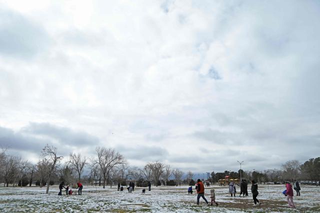 People play in the snow at El Chamizal Park in Ciudad Juarez, Chihuahua State, Mexico on January 25, 2026. (Photo by Herika MARTINEZ / AFP)