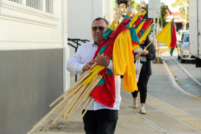 Supporters of Costa Rica's presidential candidate of the Citizen Agenda Coalition and former first lady, Claudia Dobles, carry flags during her closing campaign rally at the Mercadito La California in San Jose on January 25, 2026. Right-wing politician Laura Fernandez appears set to win Costa Rica's presidential election in the first round, according to two opinion polls published on January 21. (Photo by Marvin CARAVACA / AFP)
