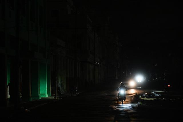 A motorcyclist rides on a street during a blackout in Havana on January 25, 2026. (Photo by YAMIL LAGE / AFP)