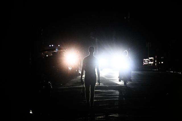 A man walks on a street during a blackout in Havana on January 25, 2026. (Photo by YAMIL LAGE / AFP)