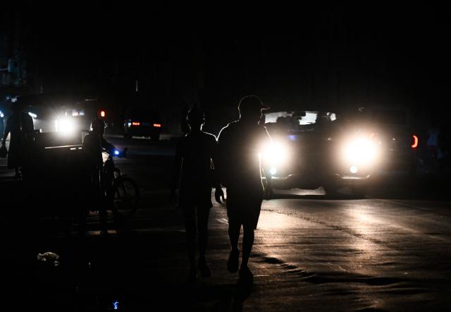A motorcyclist rides on a street during a blackout in Havana on January 25, 2026. (Photo by YAMIL LAGE / AFP)