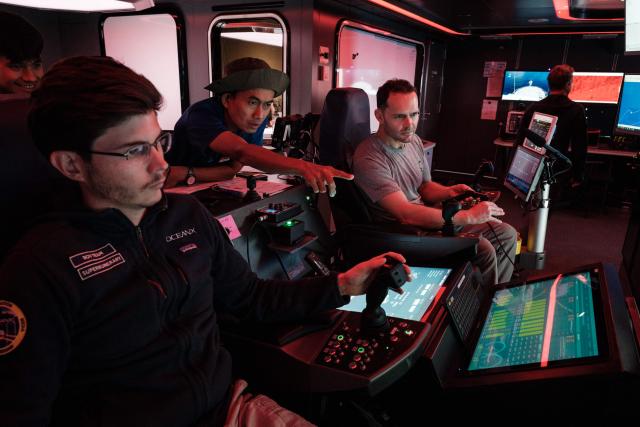 TOPSHOT - This photo taken on January 10, 2026 shows the crew of the OceanXplorer, a research vessel operated by the marine non-profit OceanX, operating a remotely operated vehicle (ROV) in a control room while marine scientists monitor deep-sea feeds in the waters off Sulawesi island. A dome-fronted submersible sinks beneath the waves off Indonesia, heading nearly 1,000 metres down to the realm of purple-frilled corals and bioluminescent shrimp. This month, AFP boarded one of two submersibles belonging to OceanX, a non-profit founded by billionaire Ray Dalio and his son that works with scientists on its OceanXplorer ship to study the marine world. (Photo by YASUYOSHI CHIBA / AFP) / To go with 'INDONESIA-OCEANX-OCEANS-ENVIRONMENT-RESEARCH-SCIENCE' by Sara HUSSEIN
