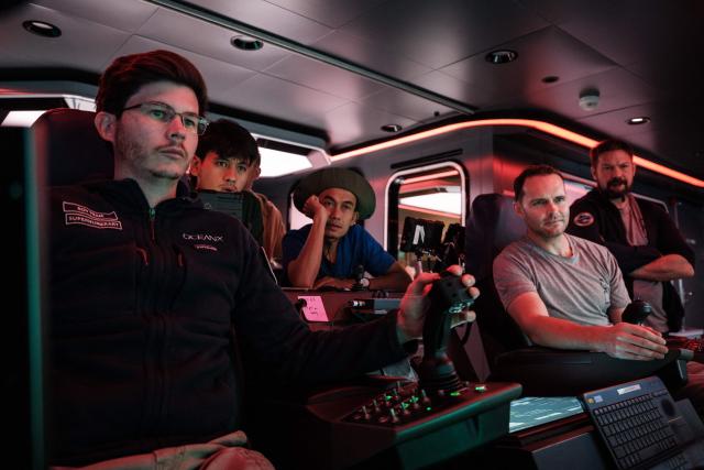 This photo taken on January 10, 2026 shows the crew of the OceanXplorer, a research vessel operated by the marine non-profit OceanX, operating a remotely operated vehicle (ROV) in a control room while marine scientists monitor deep-sea feeds in the waters off Sulawesi island. A dome-fronted submersible sinks beneath the waves off Indonesia, heading nearly 1,000 metres down to the realm of purple-frilled corals and bioluminescent shrimp. This month, AFP boarded one of two submersibles belonging to OceanX, a non-profit founded by billionaire Ray Dalio and his son that works with scientists on its OceanXplorer ship to study the marine world. (Photo by YASUYOSHI CHIBA / AFP) / To go with 'INDONESIA-OCEANX-OCEANS-ENVIRONMENT-RESEARCH-SCIENCE' by Sara HUSSEIN