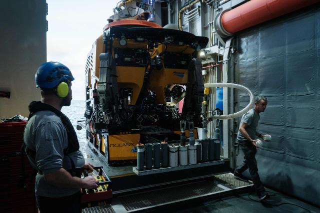 This photo taken on January 10, 2026 shows a remotely operated vehicle (ROV) being recovered from the sea by the crew of the OceanXplorer, a research vessel operated by the marine non-profit OceanX, after a deep-sea mission in the waters off Sulawesi island. A dome-fronted submersible sinks beneath the waves off Indonesia, heading nearly 1,000 metres down to the realm of purple-frilled corals and bioluminescent shrimp. This month, AFP boarded one of two submersibles belonging to OceanX, a non-profit founded by billionaire Ray Dalio and his son that works with scientists on its OceanXplorer ship to study the marine world. (Photo by YASUYOSHI CHIBA / AFP) / To go with 'INDONESIA-OCEANX-OCEANS-ENVIRONMENT-RESEARCH-SCIENCE' by Sara HUSSEIN