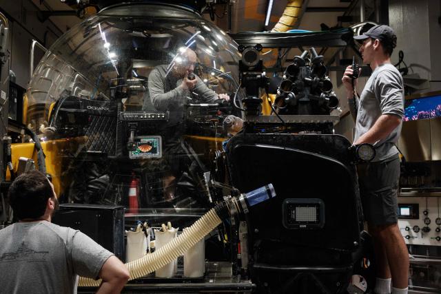 This photo taken on January 12, 2026, shows submersible pilots and crew inspecting the vessel before a deep-sea mission on the OceanXplorer, a research vessel operated by the marine non-profit OceanX, in the waters off Sulawesi island. A dome-fronted submersible sinks beneath the waves off Indonesia, heading nearly 1,000 metres down to the realm of purple-frilled corals and bioluminescent shrimp. This month, AFP boarded one of two submersibles belonging to OceanX, a non-profit founded by billionaire Ray Dalio and his son that works with scientists on its OceanXplorer ship to study the marine world. (Photo by YASUYOSHI CHIBA / AFP) / To go with: INDONESIA-OCEANX-OCEANS-ENVIRONMENT-RESEARCH-SCIENCE, by Sara HUSSEIN