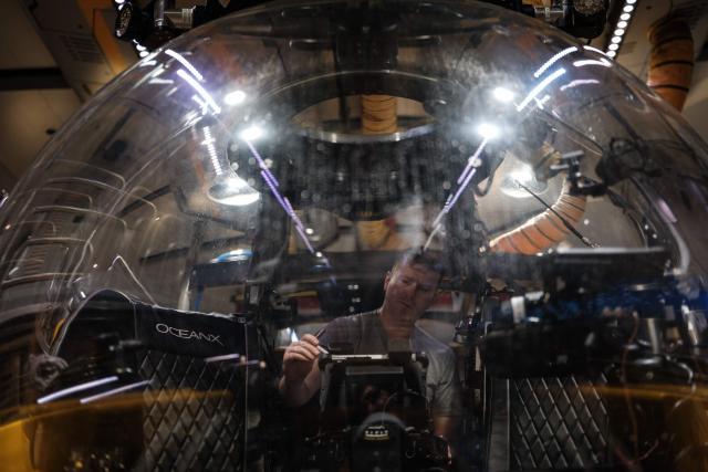 TOPSHOT - This photo taken on January 12, 2026, shows a submersible pilot inspecting the vessel before a deep-sea mission on the OceanXplorer, a research vessel operated by the marine non-profit OceanX, in the waters off Sulawesi island. A dome-fronted submersible sinks beneath the waves off Indonesia, heading nearly 1,000 metres down to the realm of purple-frilled corals and bioluminescent shrimp. This month, AFP boarded one of two submersibles belonging to OceanX, a non-profit founded by billionaire Ray Dalio and his son that works with scientists on its OceanXplorer ship to study the marine world. (Photo by YASUYOSHI CHIBA / AFP) / To go with: INDONESIA-OCEANX-OCEANS-ENVIRONMENT-RESEARCH-SCIENCE, by Sara HUSSEIN