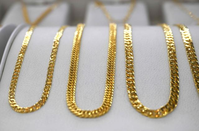 Gold jewelry is displayed at a store of the Korea Gold Exchange in Seoul on January 26, 2026. The price of safe-haven asset gold surpassed $5,000 on January 25, hitting a record amid rising global uncertainty and turmoil set off by US President Donald Trump's policies. (Photo by Jung Yeon-je / AFP)