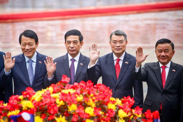Members of Vietnam's politburo (L-R) Public Security Minister Luong Tam Quang, Defence Minister Phan Van Giang, Head of the central organisation commission Le Minh Hung and Permanent member of the secretariat Tran Cam Tu wave during a welcoming ceremony at the presidential palace in Hanoi on January 26, 2026. (Photo by LUONG THAI LINH / POOL / AFP)