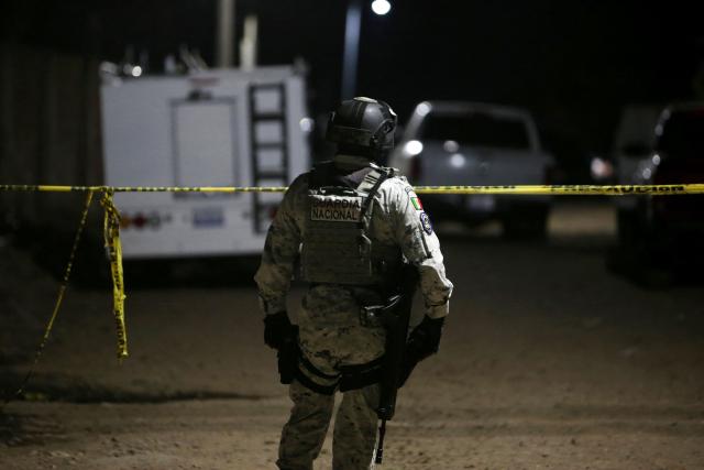 TOPSHOT - A member of the National Guard stands at the crime scene where at least 11 people were killed and 12 more wounded during an armed attack at a football field in Salamanca, Guanajuato state, Mexico, on January 25, 2026. The attack occurred in a neighborhood in the town of Salamanca, with a statement from the mayor's office saying that officials launched an operation to find those responsible for the assault. (Photo by Mario Armas / AFP)