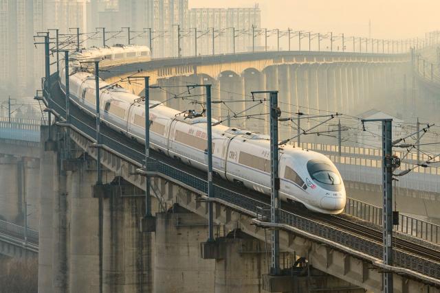 A high speed train runs on elevated tracks in Nanjing, in China’s eastern Jiangsu province on January 25, 2026. China will introduce a new national train schedule from January 26, with 12,130 scheduled passenger trains and 23,748 freight trains operating across the country, including high speed trains. (Photo by AFP) / China OUT