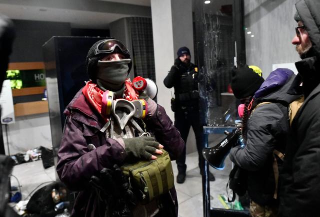 A Minneapolis Police Officer (C) stands guard as protesters participate in the "ICE OUT! Noise Demo" at the entrance of a hotel in Minneapolis, Minnesota on January 25, 2026. On January 24, federal agents shot dead US citizen Alex Pretti, a 37-year-old ICU nurse, while scuffling with him on an icy roadway, less than three weeks after an immigration officer shot and killed Renee Good, also 37, in her car.
His killing sparked new protests and impassioned demands by local leaders for the Trump administration to end its operation in the city. (Photo by Octavio JONES / AFP)