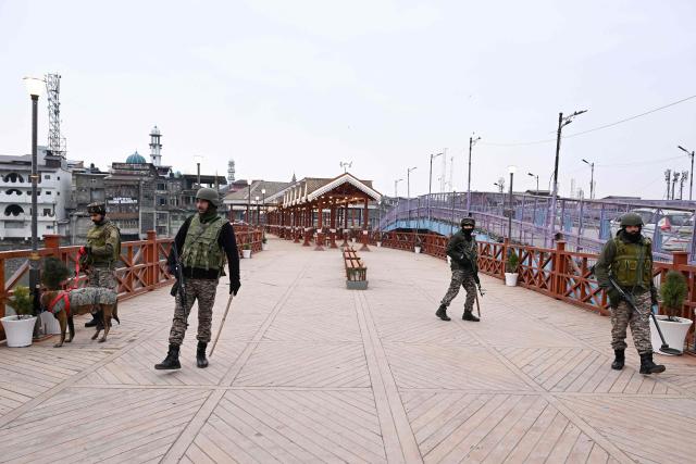 Indian paramilitary troopers stand guard on a bridge during India's 77th Republic Day celebrations in Srinagar on January 26, 2026. (Photo by Tauseef MUSTAFA / AFP)