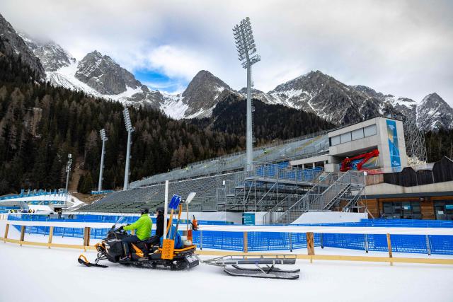 (FILES) Staff members work on the snow prepping at the Biathlon venue in Antholz, northern Italy prior to the Milano Cortina 2026 Olympic Games, on January 23, 2026. (Photo by Odd ANDERSEN / AFP)