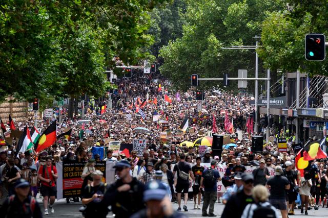 Demonstrators take part in the annual "Invasion Day" rally through the streets of Sydney on Australia Day on January 26, 2026. Tens of thousands of Australians protested over the treatment of Indigenous people as they rallied on a contentious national holiday that also marks the arrival of European colonists more than 200 years ago. (Photo by Steven Markham / AFP)