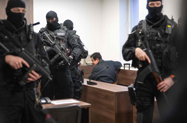 Slovak businessman Marian Kocner, accused of ordering the killing of journalist Jan Kuciak and his fiancee Martina Kusnirova, is guarded by armed police as he attends a retrial at Slovak Specialized court in Pezinok, Slovakia, on January 26, 2026. Jan Kuciak, a journalist investigating high-level corruption linked to influential businessmen and top politicians, was shot dead with his fiancee, Martina Kusnirova, both 27, at their home in the village of Velka Maca in February 2018. Their deaths sparked the largest protests in Slovakia since the fall of Communism, leading to the resignation of the government of Robert Fico, although the nationalist prime minister returned to power in 2023. (Photo by Joe Klamar / AFP)