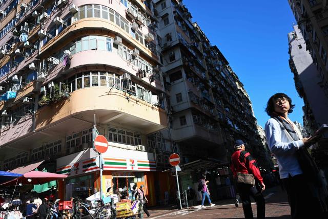 Pedestrians walk past as mid-century corner house architecture is seen in the Sham Shui Po district of Hong Kong on January 26, 2026. (Photo by Peter PARKS / AFP)