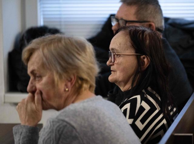 Zlatica Kusnirova (front) mother of Martina Kusnirova, and the parents of Jan Kuciak Jana Kuciakova (C) and Jozef Kuciak (back) attend the retrial of Slovak businessman Marian Kocner (unseen), accused of ordering the killing of journalist Jan Kuciak and his fiancee Martina Kusnirova, is guarded by armed police as he attends a retrial at Slovak Specialized court in Pezinok, Slovakia, on January 26, 2026. Jan Kuciak, a journalist investigating high-level corruption linked to influential businessmen and top politicians, was shot dead with his fiancee, Martina Kusnirova, both 27, at their home in the village of Velka Maca in February 2018. Their deaths sparked the largest protests in Slovakia since the fall of Communism, leading to the resignation of the government of Robert Fico, although the nationalist prime minister returned to power in 2023. (Photo by Joe Klamar / AFP)