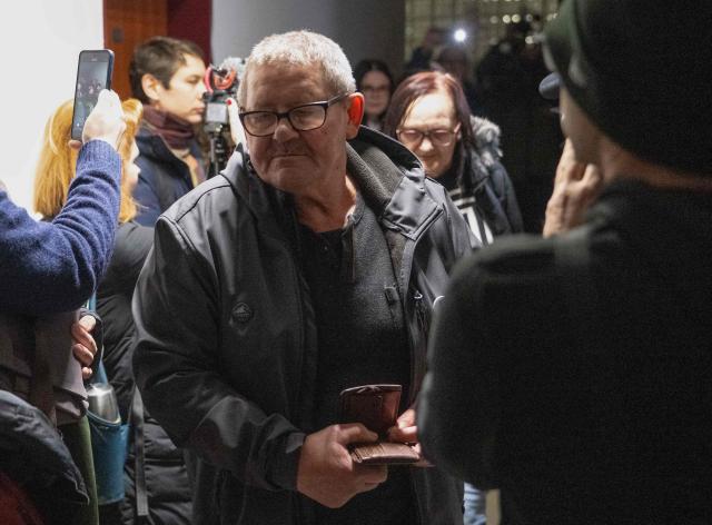 The parents of Jan Kuciak, Jozef Kuciak and Jana Kuciakova (back) arrive for the retrial of Slovak businessman Marian Kocner (unseen), accused of ordering the killing of journalist Jan Kuciak and his fiancee Martina Kusnirova, is guarded by armed police as he attends a retrial at Slovak Specialized court in Pezinok, Slovakia, on January 26, 2026. Jan Kuciak, a journalist investigating high-level corruption linked to influential businessmen and top politicians, was shot dead with his fiancee, Martina Kusnirova, both 27, at their home in the village of Velka Maca in February 2018. Their deaths sparked the largest protests in Slovakia since the fall of Communism, leading to the resignation of the government of Robert Fico, although the nationalist prime minister returned to power in 2023. (Photo by Joe Klamar / AFP)