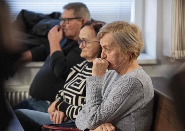 Zlatica Kusnirova (front) mother of Martina Kusnirova, and the parents of Jan Kuciak Jana Kuciakova (C) and Jozef Kuciak (back) attend the retrial of Slovak businessman Marian Kocner (unseen), accused of ordering the killing of journalist Jan Kuciak and his fiancee Martina Kusnirova, is guarded by armed police as he attends a retrial at Slovak Specialized court in Pezinok, Slovakia, on January 26, 2026. Jan Kuciak, a journalist investigating high-level corruption linked to influential businessmen and top politicians, was shot dead with his fiancee, Martina Kusnirova, both 27, at their home in the village of Velka Maca in February 2018. Their deaths sparked the largest protests in Slovakia since the fall of Communism, leading to the resignation of the government of Robert Fico, although the nationalist prime minister returned to power in 2023. (Photo by Joe Klamar / AFP)