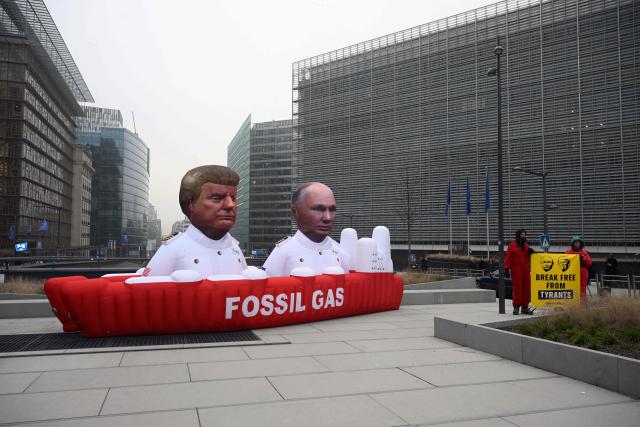Greenpeace activists demonstrate in front of an inflatable tanker with balloons in the likeness of US President Donald Trump and Russia's President Vladimir Putin displayed by Greenpeace activists to demonstrate against fossil gas next to the European Council in Brussels on January 26, 2026. As the European Union seeks a ban on Russian gas imports, Greenpeace calls for the EU not to replace Russian gas with gas from the US. (Photo by Nicolas TUCAT / AFP)