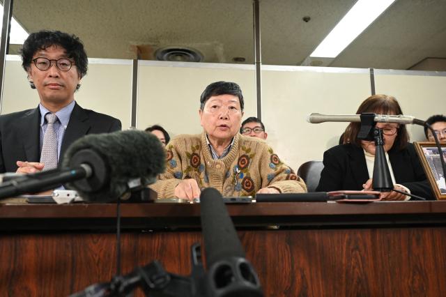 One of the plaintiffs Eiko Kawasaki (C) and chief lawyer Kenji Fukuda (L) hold a press conference in Tokyo on January 26, 2026, following a court ruling ordering the North Korean government to pay compensation over the repatriation program to North Korea. A Tokyo court ordered Pyongyang on January 26 to pay more than 500,000 USD in compensation to four people lured to North Korea by a fantastical propaganda scheme promising a "paradise on Earth". (Photo by JIJI Press / AFP) / Japan OUT