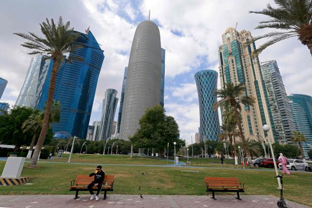 A man sits along the Corniche area on a cloudy day in Doha on January 26, 2026. (Photo by Karim JAAFAR / AFP)