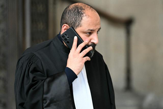 Ouadie Elhamamouchi, lawyer of Abdelhakim Sefrioui speaks on the phone during a break of the appeal trial of four people accused of involvement in the jihadist beheading of schoolteacher Samuel Paty in 2020, at the Palais de Justice, Paris' courthouse on January 26, 2026. Samuel Paty, 47, was beheaded in October 2020 by an 18-year-old Islamist radical of Chechen origin after showing cartoons of the Prophet Mohammed in class. His killer, Abdoullakh Anzorov, later died in a shootout with the police. (Photo by Bertrand GUAY / AFP)