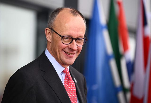 German Chancellor Friedrich Merz smiles prior to the arrival of state leaders for the North Sea Summit on January 26, 2026 in Hamburg, northern Germany. European leaders meet to discuss North Sea energy and security cooperation, but fears over US designs on the Arctic island of Greenland may overshadow the talks. The region has long worried about threats posed by Russia -- but more recently tensions have surged over US President Donald Trump's push for the autonomous territory of Denmark. (Photo by Gregor Fischer / AFP)