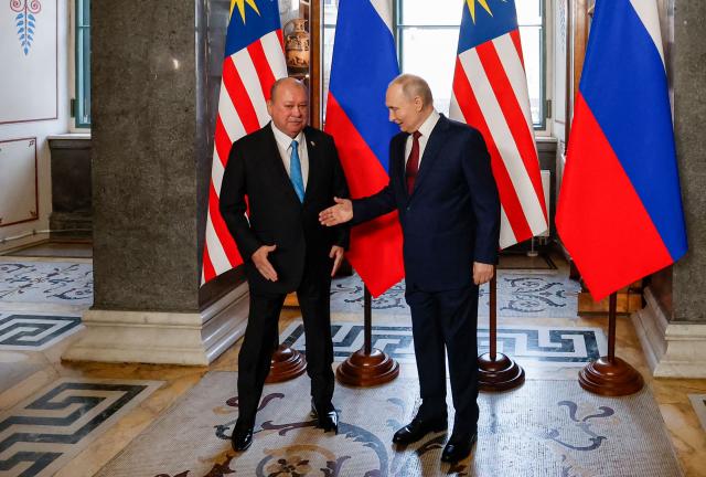 Russian President Vladimir Putin welcomes Malaysia's King Sultan Ibrahim during their meeting at the State Hermitage Museum in Saint Petersburg on January 26, 2026. (Photo by ANATOLY MALTSEV / POOL / AFP)