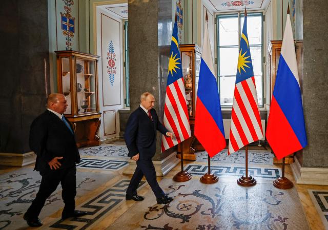 Russian President Vladimir Putin welcomes Malaysia's King Sultan Ibrahim during their meeting at the State Hermitage Museum in Saint Petersburg on January 26, 2026. (Photo by ANATOLY MALTSEV / POOL / AFP)