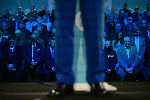 Delegates including military veterans listen to Reform UK leader Nigel Farage speak during a press conference in central London on January 26, 2026, where it was announced that Britain's former Conservative party MP, and former Home Secretary Suella Braverman had defected to the party. (Photo by Ben STANSALL / AFP)
