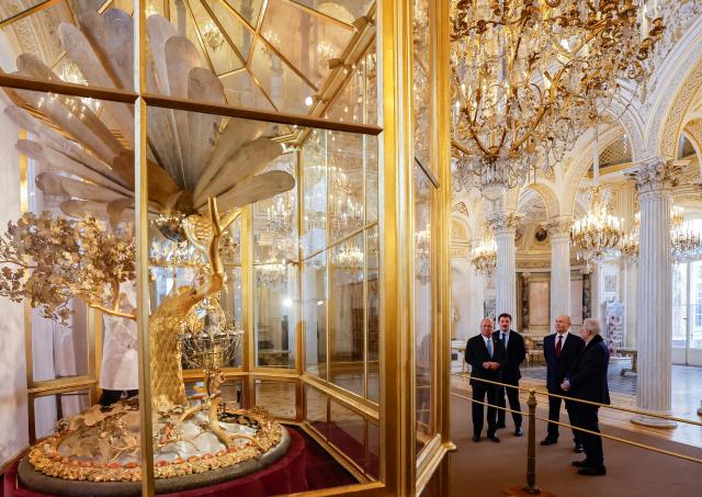 Russian President Vladimir Putin and Malaysia's King Sultan Ibrahim look at the Peacock Clock by James Cox dated from the 1770s, during their meeting at the State Hermitage Museum in Saint Petersburg on January 26, 2026. (Photo by ANATOLY MALTSEV / POOL / AFP)