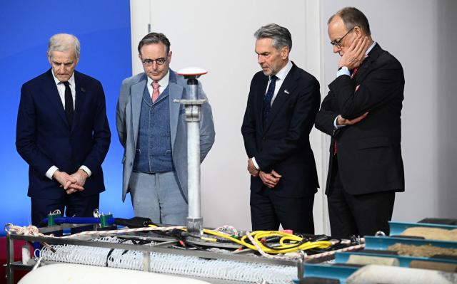 (R-L) German Chancellor Friedrich Merz, Netherland's Prime Minister Dick Schoof, Belgium's Prime Minister Bart de Wever and Norway's Prime Minister Jonas Gahr Store look at equipment from the Federal Maritime and Hydrographic Agency (BSH) as they attend the North Sea Summit on January 26, 2026 in Hamburg, northern Germany. European leaders meet to discuss North Sea energy and security cooperation, but fears over US designs on the Arctic island of Greenland may overshadow the talks. The region has long worried about threats posed by Russia -- but more recently tensions have surged over US President Donald Trump's push for the autonomous territory of Denmark. (Photo by Gregor Fischer / AFP)