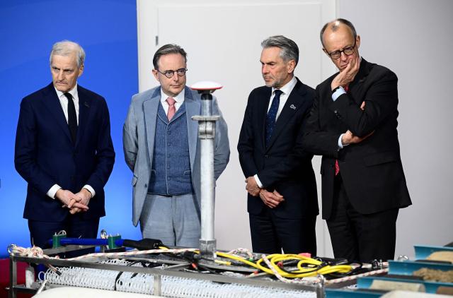 (R-L) German Chancellor Friedrich Merz, Netherland's Prime Minister Dick Schoof, Belgium's Prime Minister Bart de Wever and Norway's Prime Minister Jonas Gahr Store look at equipment from the Federal Maritime and Hydrographic Agency (BSH) as they attend the North Sea Summit on January 26, 2026 in Hamburg, northern Germany. European leaders meet to discuss North Sea energy and security cooperation, but fears over US designs on the Arctic island of Greenland may overshadow the talks. The region has long worried about threats posed by Russia -- but more recently tensions have surged over US President Donald Trump's push for the autonomous territory of Denmark. (Photo by Gregor Fischer / AFP)